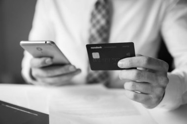 Malların online ödeme. Akıllı telefon ve Internet ticareti. Online ödeme telefon aracılığıyla. Genç işadamı onun elinde banka kredi kartıyla. Online Döviz Alım Satım ticaret.