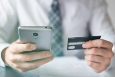 İşadamı bir smartphone ve kredi kartı online ödeme için kullanır. Gönderen e-posta, hareket eden telefon. Beyaz arka plan. Office iş kavramı. Telefonu kapatın. Online alışveriş.
