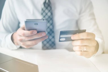 Online Döviz Alım Satım ticaret. Malların online ödeme. Akıllı telefon ve Internet ticareti. Online ödeme telefon aracılığıyla. Onun elinde banka kredi kartıyla genç işadamı.