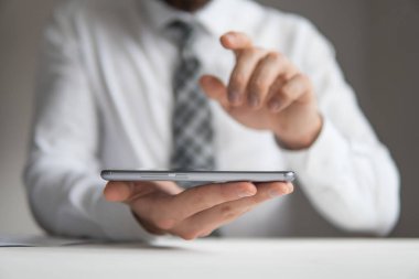 Açık renkli. İşadamı çalışma. Mali iş. Yakın çekim. Smartphone el genç işadamı sakallı. Bir dizüstü bilgisayar ile ofis işleri.
