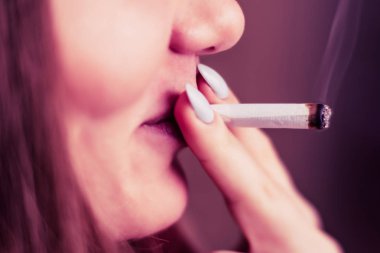 Siyah bir arka plan üzerinde duman. Bir kadın sigara esrar esrar, esrar ve onun elinde bir çakmak. Tıbbi esrar kullanım ve yasallaştırma esrar kavramları. Pembe siyah bir arka plan renklendirme