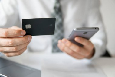 Genç işadamı onun elinde banka kredi kartıyla. Malların online ödeme. Online Döviz Alım Satım ticaret. Akıllı telefon ve Internet ticareti. Telefon aracılığıyla online ödeme.