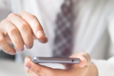 Mali iş. Yakın çekim. Smartphone el genç işadamı sakallı. Bir dizüstü bilgisayar ile ofis işleri. Açık renkli. Bilgisayarda ofis işleri tabloda ile işadamı çalışma.