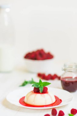 Ahududu ile panakota. Yakın çekim. Dikey vurdu. Yaz tatlı. Açık renkli.