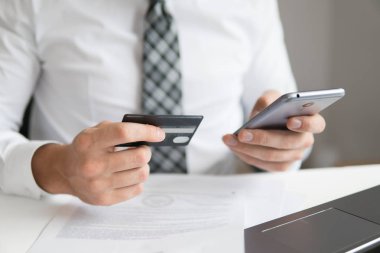Malların online ödeme. Online Döviz Alım Satım ticaret. Online ödeme telefon aracılığıyla. Akıllı telefon ve Internet ticareti. Onun elinde banka kredi kartıyla genç işadamı.