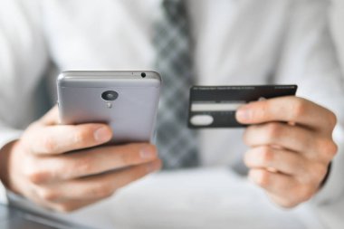 Online ödeme telefon aracılığıyla. Malların online ödeme. Genç işadamı onun elinde banka kredi kartıyla. Online Döviz Alım Satım ticaret. Akıllı telefon ve Internet ticaret.