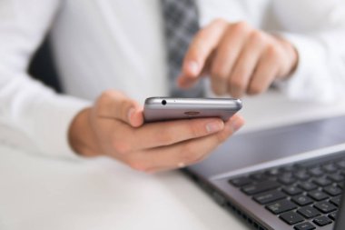 İş adamı iş bilgisayar ile ofis işleri tablo. Akıllı telefon elinde tutuyor. Bir dizüstü bilgisayar ile ofis işleri. Mali iş.