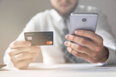 İşadamı kredi kartı ve bir akıllı telefon kullanır. Online ödeme. Hareket eden telefon. Online alışveriş. Telefonu kapatın. Office iş kavramı. Işık sızıntıları