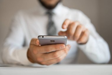 Malların online ödeme. Akıllı telefon ve Internet ticareti. Online Döviz Alım Satım ticaret. Genç işadamı onun elinde banka kredi kartıyla. Telefon aracılığıyla online ödeme.
