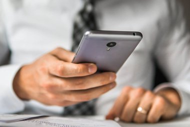 İş adamı iş bilgisayar ile ofis işleri tablo. Genç işadamı sakallı. Mali iş. Açık renkli. Bir dizüstü bilgisayar ile ofis işleri. Akıllı telefon elinde tutan.