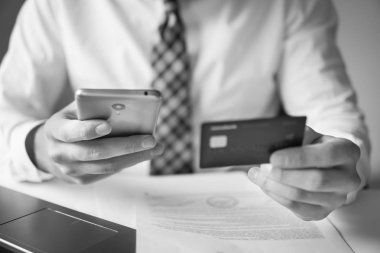 Akıllı telefon ve Internet ticareti. Genç işadamı onun elinde banka kredi kartıyla. Malların online ödeme. Online ödeme telefon aracılığıyla. Online Döviz Alım Satım ticaret.