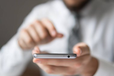 Office iş kavramı. Gönderen e-posta, hareket eden telefon. İşadamı bir akıllı telefon kullanır. Beyaz arka plan. Telefonu kapatın. Online alışveriş.