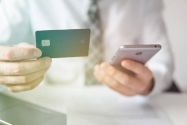 Akıllı telefon ve Internet ticareti. Online Döviz Alım Satım ticaret. Genç işadamı onun elinde banka kredi kartıyla. Online ödeme telefon aracılığıyla. Malların online ödeme.