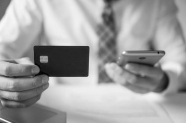 Online ödeme telefon aracılığıyla. Akıllı telefon ve Internet ticareti. Online Döviz Alım Satım ticaret. Genç işadamı onun elinde banka kredi kartıyla. Malların online ödeme.