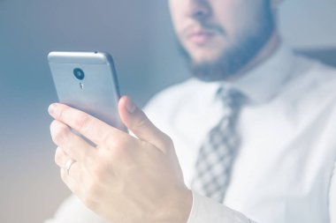 Mali iş. Bir dizüstü bilgisayar ile ofis işleri. Yakın çekim. Açık renkli. İş adamı iş bilgisayar ile ofis işleri tablo. Smartphone el genç işadamı sakallı.