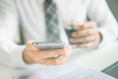 İşadamı bir akıllı telefon kullanır. Telefonu kapatın. Gönderen e-posta, hareket eden telefon. Online alışveriş. Office iş kavramı. Beyaz arka plan. Işık sızıntıları