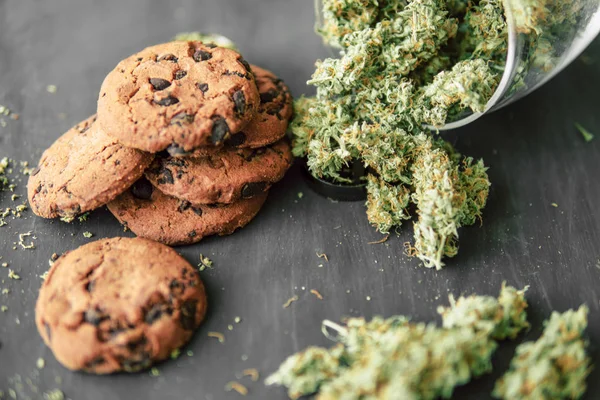 Biscoitos com maconha e botões de maconha na mesa. Conceito de cozinhar com erva de cannabis . — Fotografia de Stock