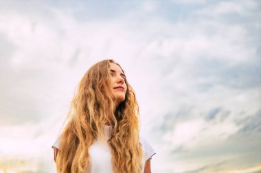 Gökyüzü ve bulutlar bir arka plan beyaz bir kadın. Feminizm ve güzellik. Kadın hakları kendine güven kavramı zorlar. cinsiyet eşitliği mücadelesi .