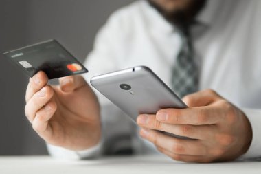 Online ödeme telefon aracılığıyla. Malların online ödeme. Akıllı telefon ve Internet ticareti. Online Döviz Alım Satım ticaret. Onun elinde banka kredi kartıyla genç işadamı.