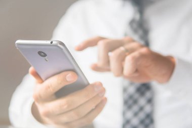 Office iş kavramı. Beyaz arka plan. Telefonu kapatın. İşadamı bir akıllı telefon kullanır. Online alışveriş. Gönderen e-posta, hareket eden telefon. Işık sızıntıları