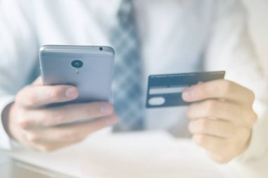 İşadamı bir smartphone ve kredi kartı online ödeme için kullanır. Gönderen e-posta, hareket eden telefon. Beyaz arka plan. Office iş kavramı. Online alışveriş. Telefonu kapatın. Işık sızıntıları