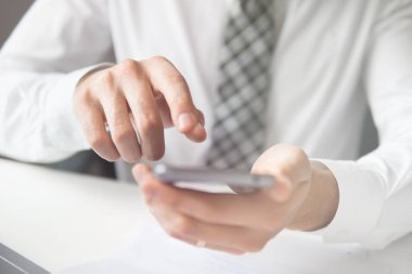 Bir dizüstü bilgisayar ile ofis işleri. Açık renkli. Yakın çekim. İş adamı iş bilgisayar ile ofis işleri tablo. Mali iş. Smartphone el genç işadamı sakallı.