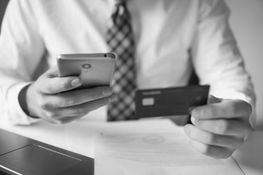 Genç işadamı onun elinde banka kredi kartıyla. Malların online ödeme. Online ödeme telefon aracılığıyla. Online Döviz Alım Satım ticaret. Akıllı telefon ve Internet ticaret.