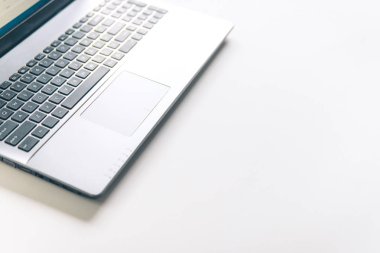 Ahşap masa üzerinde dizüstü bilgisayar. Beyaz teknolojik arka plan. üstten görünüm kopya alanı.