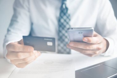 Online ödeme telefon aracılığıyla. Malların online ödeme. Genç işadamı onun elinde banka kredi kartıyla. Online Döviz Alım Satım ticaret. Akıllı telefon ve Internet ticaret.