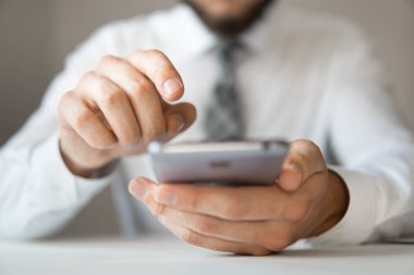 Online Döviz Alım Satım ticaret. Akıllı telefon ve Internet ticareti. Malların online ödeme. Genç işadamı onun elinde banka kredi kartıyla. Telefon aracılığıyla online ödeme.