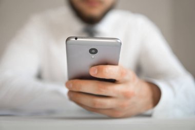 Genç işadamı ile smartphone onun elinde. Online ödeme telefon aracılığıyla. Online Döviz Alım Satım ticaret. Akıllı telefon ve Internet ticareti. Malların online ödeme.