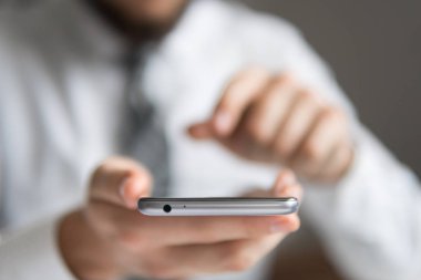 Bir dizüstü bilgisayar ile ofis işleri. İş adamı iş bilgisayar ile ofis işleri tablo. Mali iş. Açık renkli. Akıllı telefon elinde tutan.