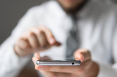 Bir dizüstü bilgisayar ile ofis işleri. İş adamı iş bilgisayar ile ofis işleri tablo. Genç işadamı sakallı. Açık renkli. Mali iş. Akıllı telefon elinde tutan.