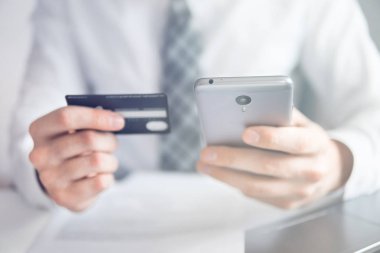 Malların online ödeme. Online ödeme telefon aracılığıyla. Genç işadamı onun elinde banka kredi kartıyla. Online Döviz Alım Satım ticaret. Akıllı telefon ve Internet ticaret.