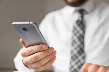 Bir dizüstü bilgisayar ile ofis işleri. Mali iş. Açık renkli. İş adamı iş bilgisayar ile ofis işleri tablo. Akıllı telefon elinde tutan.