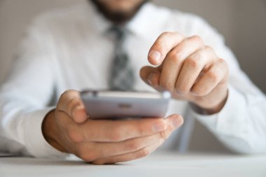 İşadamı bir smartphone telefon kadar yakın kullanır. Gönderen e-posta, hareket eden telefon. Office iş kavramı. İşadamı belgeleriyle çalışma