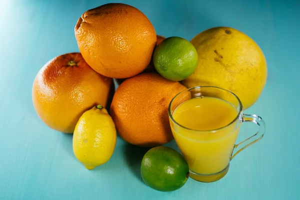 Zitrusfrüchte, Orange, Limette, Zitrone, Pomelo, Grapefruit mit Orangensaft im Glas — Stockfoto