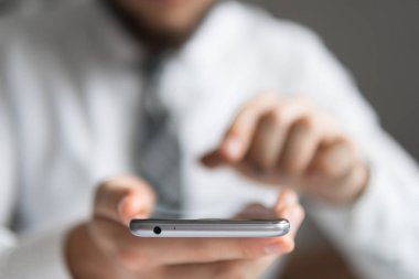 Mali iş. Açık renkli. Yakın çekim. Bir dizüstü bilgisayar ile ofis işleri. Smartphone elinde. Genç işadamı sakallı. Bilgisayarda ofis işleri tabloda ile işadamı çalışma.