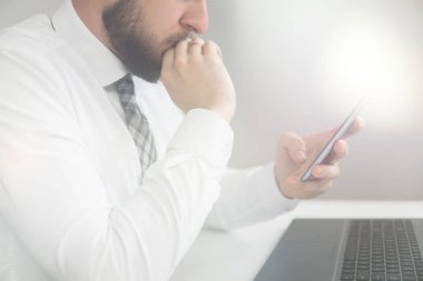 Açık renkli. Yakın çekim. Bir dizüstü bilgisayar ile ofis işleri. Mali iş. Smartphone el genç işadamı sakallı. Bilgisayarda ofis işleri tabloda ile işadamı çalışma.