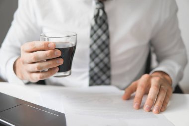 ofis işleri tablo belgelerle çalışmak. Mali belgeler iş. Yakın çekim. Bir dizüstü bilgisayar ile ofis işleri. Açık renkli. Smartphone el genç işadamı sakallı. Espresso kahve.