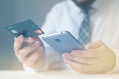 İşadamı kredi kartı ve bir akıllı telefon kullanır. Online ödeme. Hareket eden telefon. Online alışveriş. Telefonu kapatın. Office iş kavramı. Işık sızıntıları