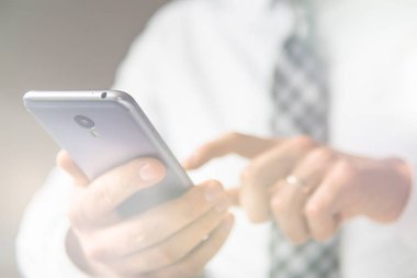 Beyaz arka plan. Telefonu kapatın. İşadamı bir akıllı telefon kullanır. Online alışveriş. Gönderen e-posta, hareket eden telefon. Office iş kavramı. ışık sızıntıları