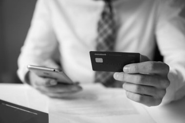 Akıllı telefon ve Internet ticareti. Genç işadamı onun elinde banka kredi kartıyla. Online Döviz Alım Satım ticaret. Malların online ödeme. Telefon aracılığıyla online ödeme.