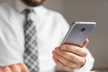 İş adamı iş bilgisayar ile ofis işleri tablo. Genç işadamı sakallı. Mali iş. Açık renkli. Bir dizüstü bilgisayar ile ofis işleri. Akıllı telefon elinde tutan.