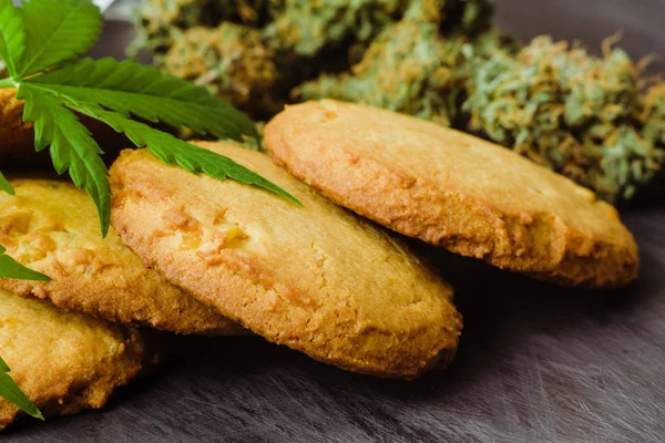 Godis med ogräs. Cookies med marijuana. Godis med cannabis. Cannabis knoppar på en svart bakgrund. Bakning med tillägg av Cbd. — Stockfoto