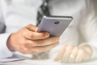 İşadamı bir akıllı telefon kullanır. Gönderen e-posta, hareket eden telefon. Online alışveriş. Office iş kavramı. Beyaz arka plan. Telefonu kapatın. ışık sızıntıları