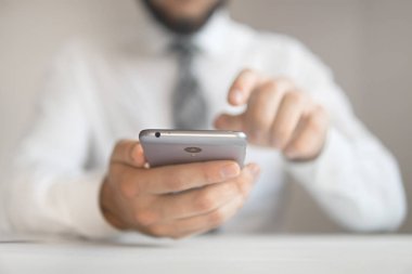 İşadamı bir smartphone telefon kadar yakın kullanır. Office iş kavramı. Beyaz arka plan belgeleriyle çalışma iş adamı. Online alışveriş.