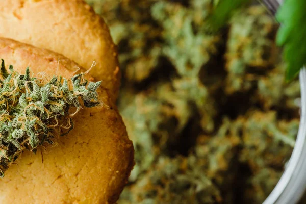 Cannabis knoppar på en svart bakgrund. Bakning med tillägg av Cbd. godis med ogräs. Cookies med marijuana. Godis med cannabis. — Stockfoto