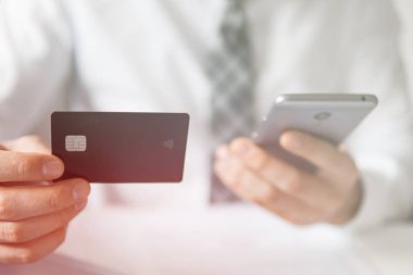 İşadamı online ödeme için kredi kartı ve bir akıllı telefon kullanır. Office iş kavramı. Online alışveriş. Telefonu kapatın. Beyaz arka plan. Gönderen e-posta, hareket eden telefon. ışık sızıntıları
