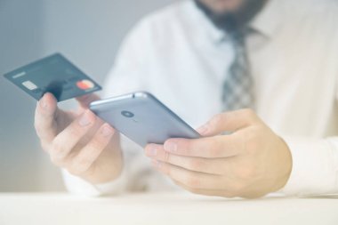 İş adamı iş bilgisayar ile ofis işleri tablo. Açık renkli. Bir dizüstü bilgisayar ile ofis işleri. Mali iş. Yakın çekim. Smartphone el genç işadamı sakallı.